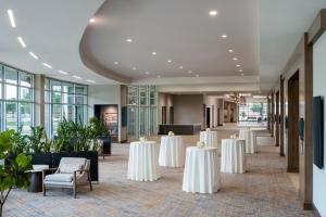 威奇托福尔斯Delta Hotels by Marriott Wichita Falls Convention Center的宴会厅配有白色的桌椅