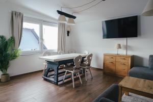 克拉根福Stadtapartment KUS的客厅配有桌椅和电视。