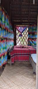 LoanengoGlowing Mountain view tree house的客房设有两张床和一个带毯子的窗户。