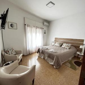 上格拉西亚248 Apartamento的白色卧室配有床和椅子