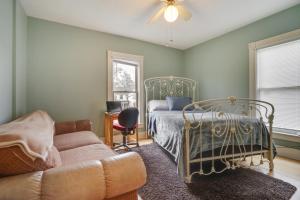 欧克莱尔Eau Claire Retreat Close to Chippewa Riverfront!的一间卧室配有一张床和一张沙发