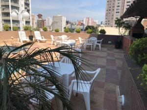 库里提巴Rede Andrade São Francisco的屋顶上配有白色椅子和桌子的庭院