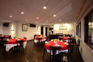 库里提巴Rede Andrade São Francisco的一间设有红色和白色桌椅的用餐室