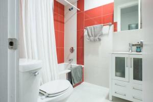 纽约New Prime Gramercy Subway W D in unit的浴室设有白色卫生间和红色墙壁。