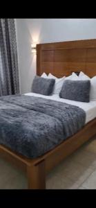DschangJAD HOTEL Dschang的一间卧室配有一张带蓝色枕头的大床