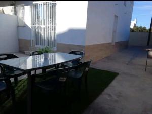 赫雷斯-德拉弗龙特拉Casa en Jerez con patio cerca de la playa y de la sierra的带庭院的客房内的桌椅