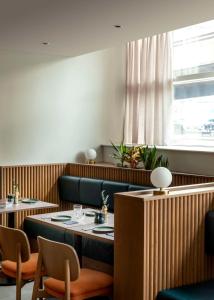 伦敦希尔顿伦敦大都会酒店的餐厅设有2张桌子和椅子以及窗户。