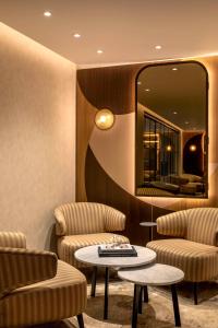 伦敦希尔顿伦敦大都会酒店的一间设有两把椅子、一张桌子和一面镜子的房间