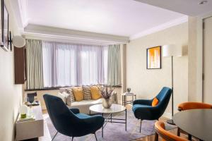 伦敦希尔顿伦敦大都会酒店的客厅配有蓝色椅子和沙发