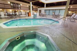 圣路易斯Pear Tree Inn St Louis Convention Center的一座带桌椅的大型游泳池