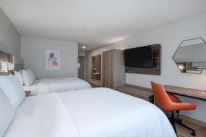 哥伦比亚哥伦比亚克莱姆森路I-20号快捷假日套房酒店的酒店客房设有两张床、一张桌子和一台电视。