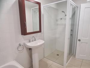 阿米代尔Moore Park Apartments的白色的浴室设有水槽和淋浴。