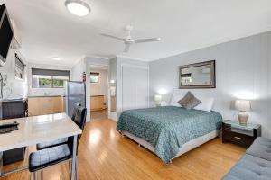 赫维湾芳娜湖保护区酒店的一间卧室配有一张床、一张书桌和一张书桌