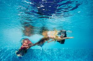 图兰奔AERO氧程巴厘岛潜水度假酒店的女人在水中游泳