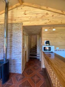 富特罗诺CABAÑAS RUCA MALAL的厨房设有木墙和带微波炉的台面。