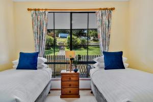 AlonnahOmaroo Cottage Bruny Island的带窗户的客房内的两张床