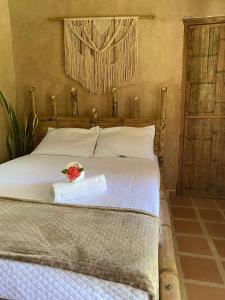 圣玛尔塔Hostal Dos Quebradas的一间卧室配有一张带一束鲜花的床