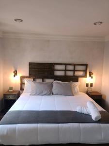 Ciudad HidalgoAñoranza Hotel Boutique的一间卧室配有一张带两盏灯的大型白色床。