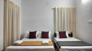 科钦KOVIL home's Guest land的两张睡床彼此相邻,位于一个房间里