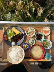镰仓市GOOD MORNING ZAIMOKUZA的餐桌,盘子上放着食物和碗