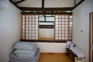 GongjuBonghwangjae Hanok Guesthouse的一间设有床铺和2扇窗户的房间
