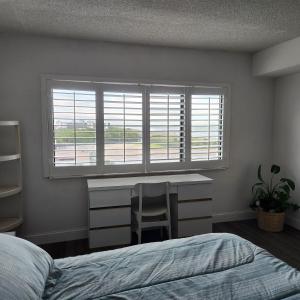 可可比奇Sandcastles Condominium Complex的一间卧室配有一张床、一张书桌和一个窗户。