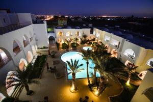 迈来亚Palm Djerba Suites的享有带游泳池和棕榈树的建筑的空中景致