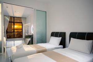 哥打京那巴鲁Just Chillin Pool & Seaview Suites的酒店客房设有两张床和窗户。