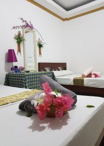公主港Hanbee's Resort的一间设有两张床的房间和一张桌子上的一篮鲜花