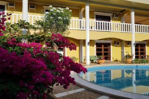 公主港Hanbee's Resort的一座带游泳池和紫色鲜花的酒店