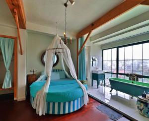 大叻Lacasa May的一间卧室配有一张床、一个浴缸和一个浴缸