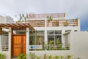 MahibadhooRaalhu Fonu Maldives的白色的房子,设有木门和阳台
