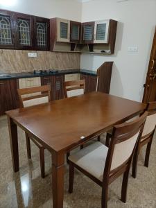 RAJAM FARM HOUSE的厨房里配有一张木桌和椅子