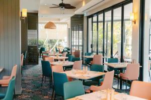 黄金海岸黄金海岸美居度假酒店的餐厅设有桌椅和窗户。