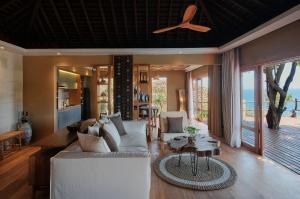 BumbangTUNAK Resort Lombok的客厅配有沙发和桌子