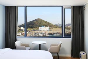 木浦市Mokpo Ocean Hotel的一间卧室设有大窗户,享有海港的景色