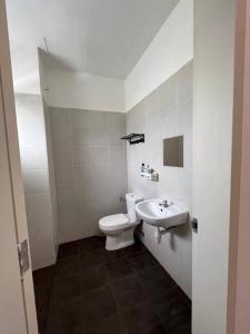 万津Homestay Bandar Mahkota Banting的白色的浴室设有卫生间和水槽。