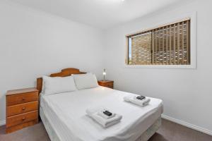 Port MoontaCostello Hotels - Moonta Bay Cabins的白色的卧室设有床和窗户