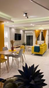 藻德济DUPLEX 101的客厅配有黄色的沙发、桌子和椅子