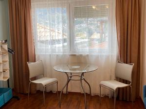 萨拉热窝Green Gate Apartments的窗前的一张桌子和两把椅子