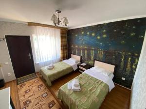 Chon-Sary-OyАрт-отель ololoFamily的一间设有两张床的客房,墙上挂着一幅画