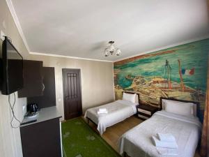 Chon-Sary-OyАрт-отель ololoFamily的酒店客房设有两张床,墙上挂有绘画作品