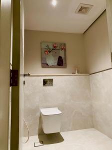 欧拉فيلا بمسبح وحديقة خاصة的一间带卫生间的浴室和墙上的绘画