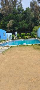 钦奈Le Grace Kovalam的一座绿树成荫的蓝色游泳池