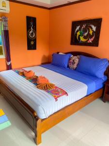 高兰Thai Smile Bungalows的橙色墙壁间的一张床位