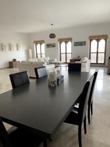 马斯喀特Jabal Sifah Marina View Apartment的客厅配有一张黑桌子和椅子