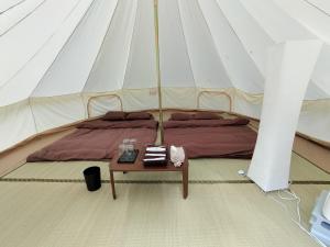 Glanchette岡山∼グランピング＆オートキャンプ∼的帐篷内的一张床位,配有桌子