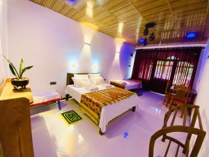 安帕赖Rathnapriya Safari Guest Galoya的卧室配有一张床和一张桌子及椅子