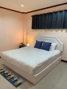 合艾BAAN OZONE的卧室配有带蓝色枕头的大型白色床