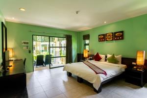 蔻立Baan Khaolak Beach Resort的一间卧室设有一张大床和绿色的墙壁